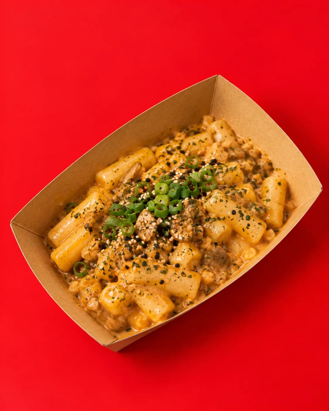 Creamy butter garlic tteokbokki topped with spring onion and sesame